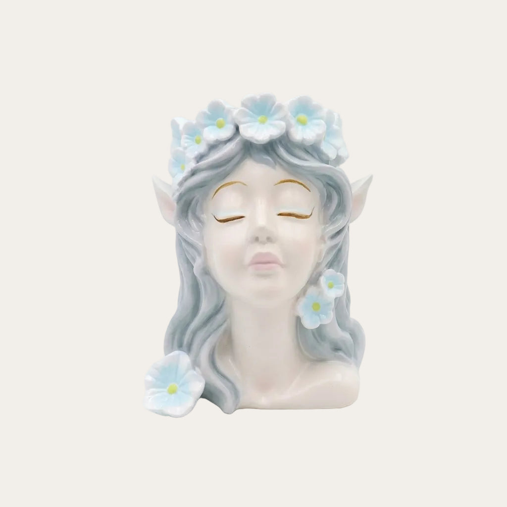 Decorative head with floral hair and earrings on a light gray background